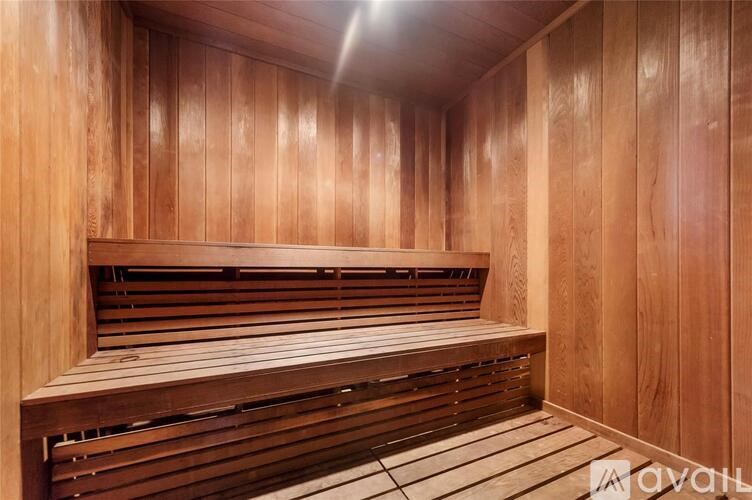 A wooden sauna with benches and a light on the ceiling.