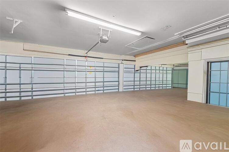 A large empty room with a wooden floor and a wall of windows.