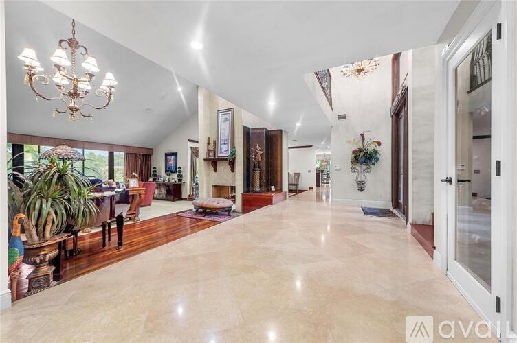 A spacious living room with a chandelier and a fireplace.