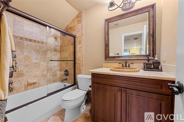 A bathroom with a toilet, sink, and mirror.