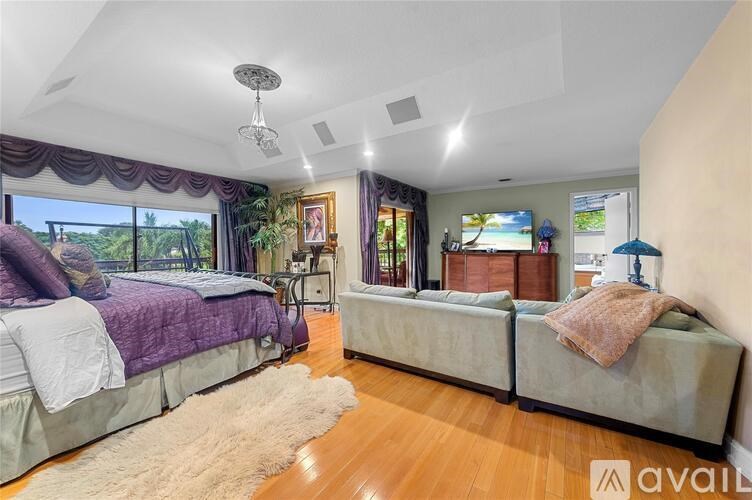 A bedroom with a large bed and a window with curtains.