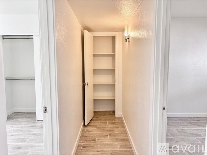 A hallway with a white door and a light on the wall.