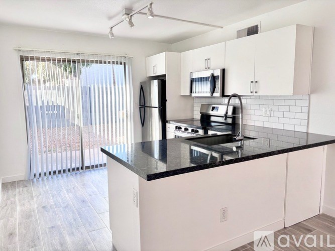 A kitchen with black countertops and white cabinets.