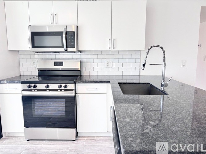 A kitchen with white cabinets and a black oven.