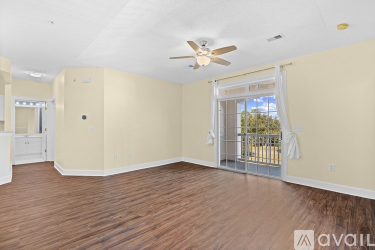 A spacious room with a ceiling fan and sliding glass doors.