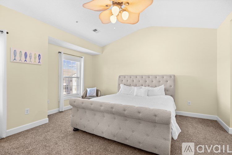A bedroom with a large bed and a ceiling fan.