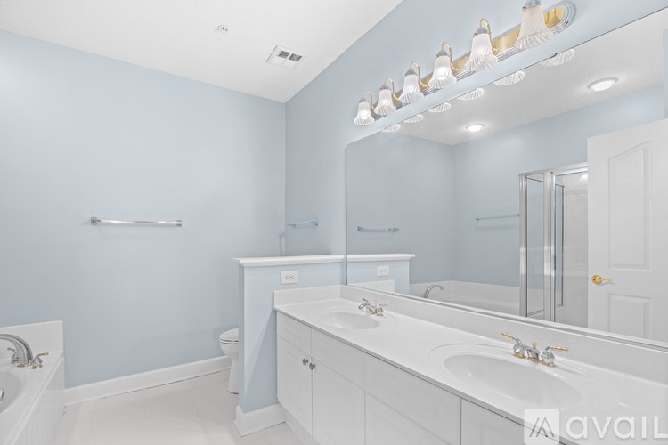 A bathroom with blue walls and white fixtures.
