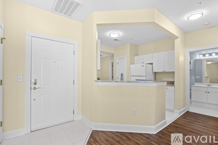 A kitchen with white cabinets and a white door.