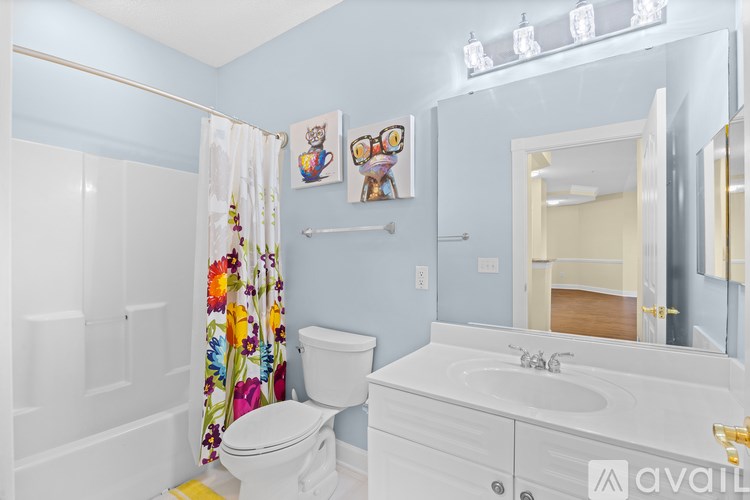 A bathroom with a white toilet, sink, and shower curtain.