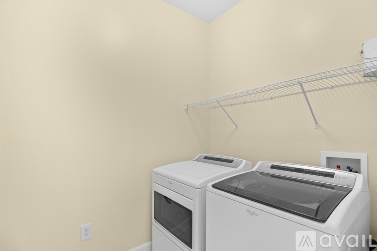 A wall-mounted shelf above a white microwave and oven.