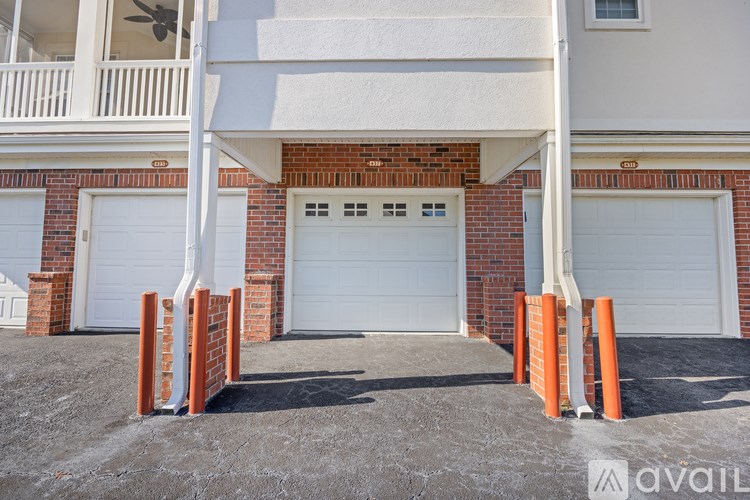A white garage door is part of a brick building.