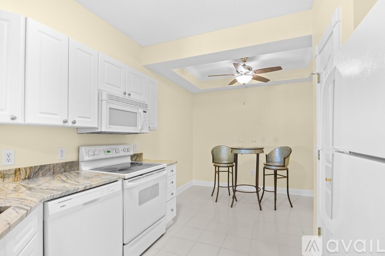 A kitchen with white appliances and a marble countertop.