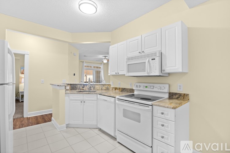 A kitchen with white appliances and cabinets.