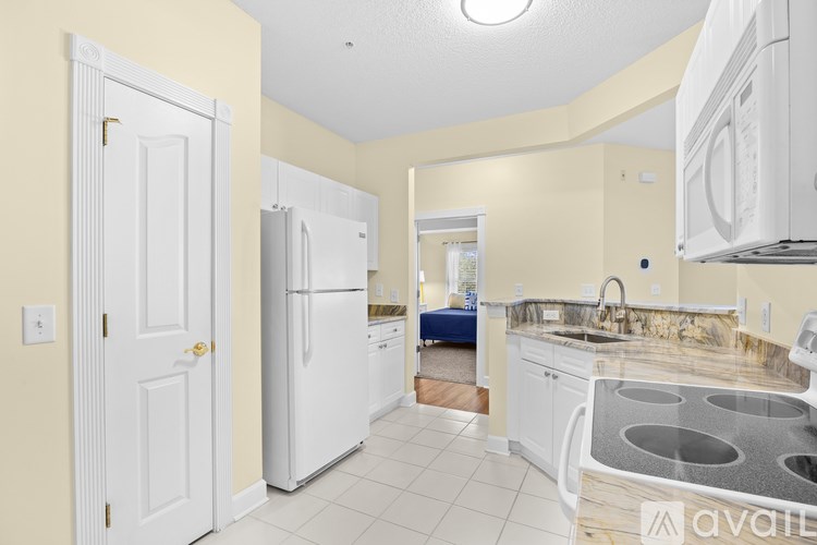 A kitchen with white appliances and a marble countertop.