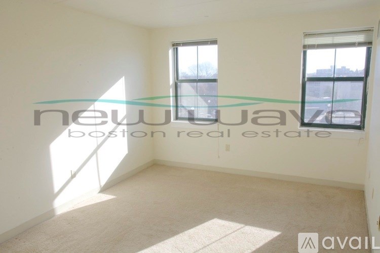 A room with a window and a carpet on the floor.