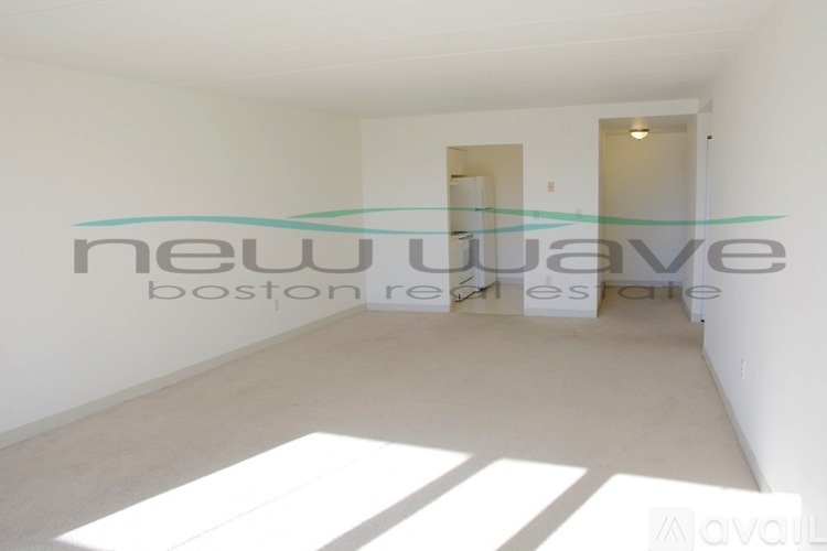 A white room with a large window and a white floor.