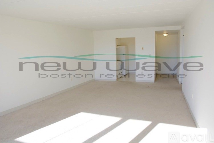 A white room with a large window and a white floor.