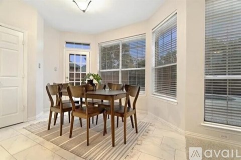 A dining room with a table and chairs.