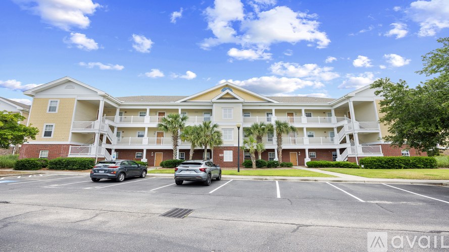 A sunny day at the apartment complex with cars parked in the lot.