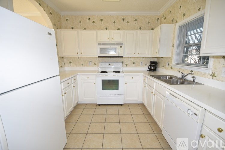 A kitchen with white appliances and cabinets.
