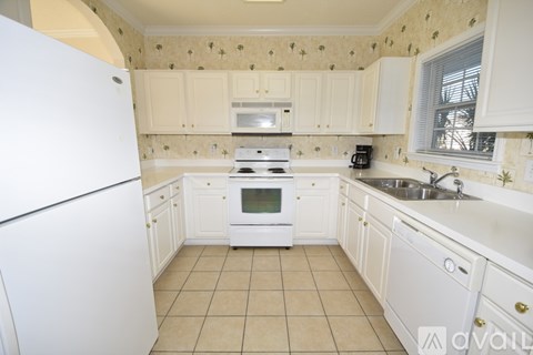 A kitchen with white appliances and cabinets.