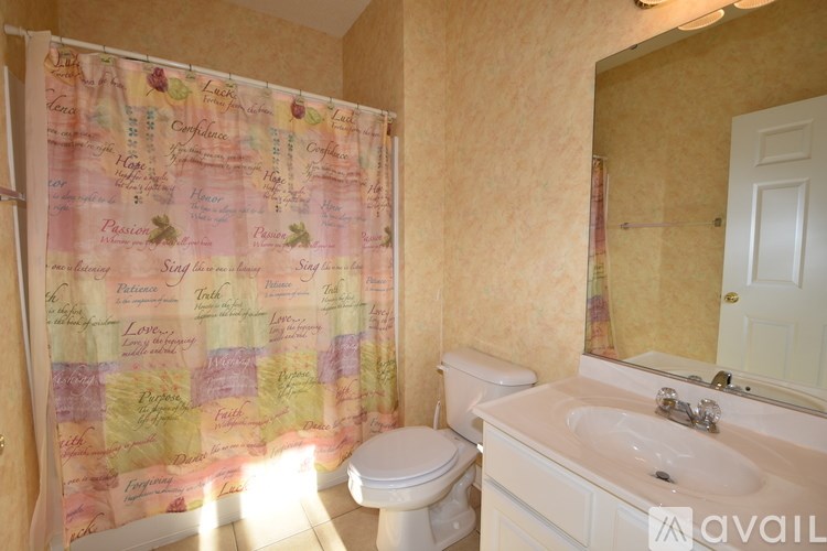 A bathroom with a shower curtain that has words like "Confidence" and "Passion" on it.