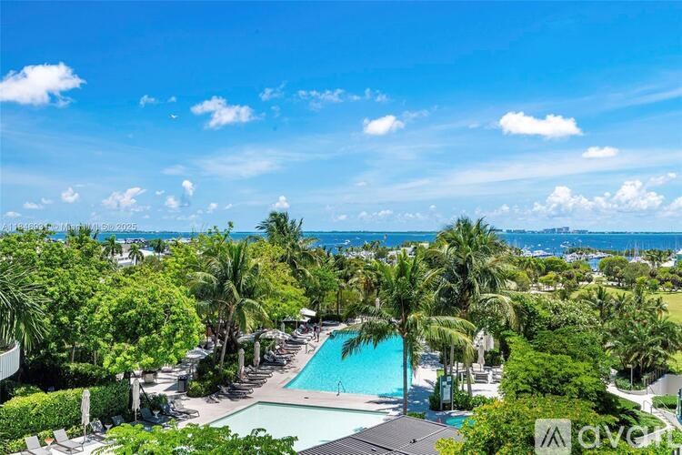 A pool surrounded by palm trees under a blue sky.