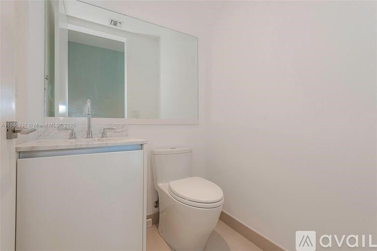A white toilet sits next to a sink in a bathroom.