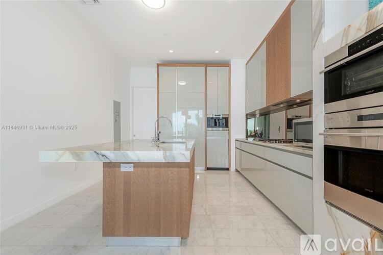 A kitchen with a marble island and modern appliances.