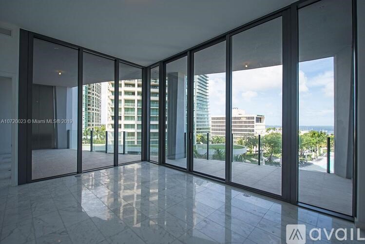 A spacious room with large glass doors leading to a balcony.
