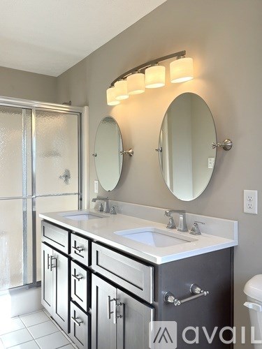 A bathroom with a sink, mirror, and cabinets.