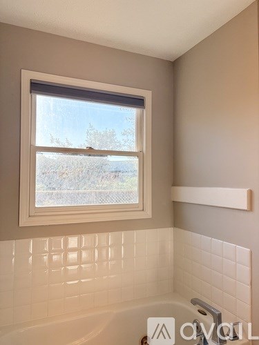 A bathroom with a tub and a window.