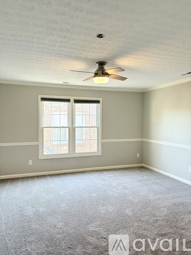 A room with a ceiling fan and a window.