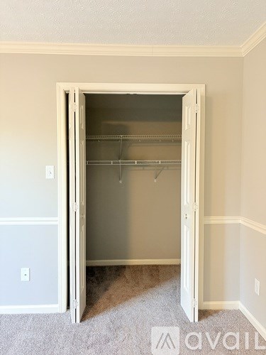 A white door is open to a room with a carpeted floor.