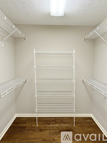 Empty white shelves in a room with wooden flooring.