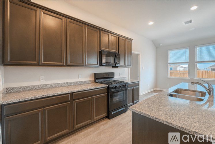 A kitchen with brown cabinets and a granite countertop.