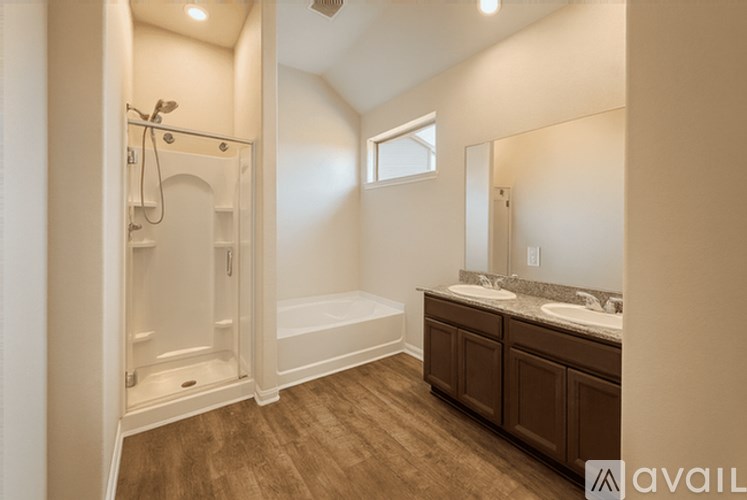 A bathroom with a wooden floor and white walls.