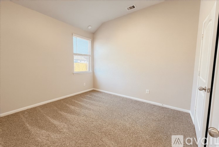 A room with a carpeted floor and a door on the right side.
