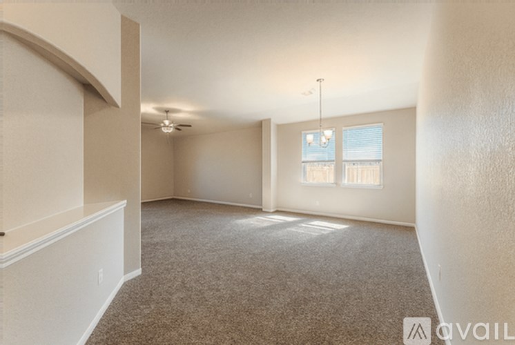 A spacious room with carpeted floor and a window with blinds.
