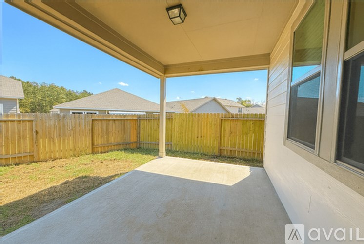 A covered porch area with a wooden fence and a clear blue sky.