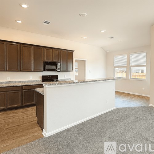 A kitchen with brown cabinets and a white island.