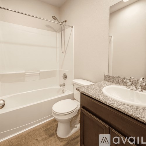 A bathroom with a toilet, sink, and bathtub.