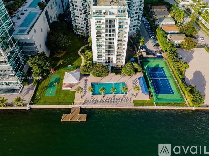 An aerial view of a resort with a pool and tennis courts.