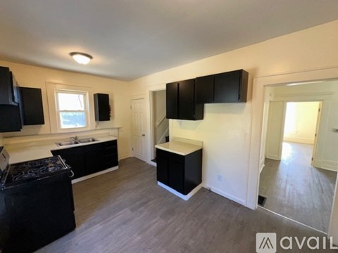 A kitchen area with black cabinets and a stove top oven.