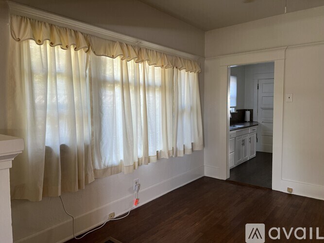 A room with a fireplace and a window with curtains.