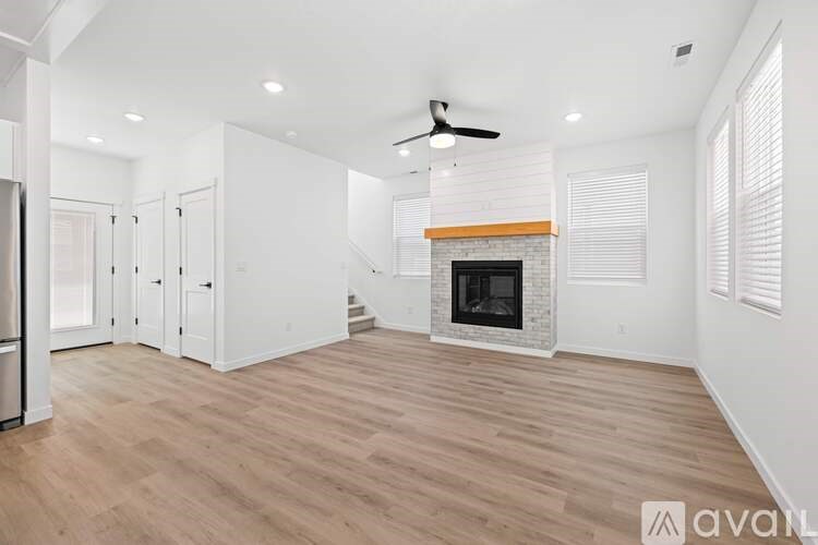 A spacious living room with a fireplace and wood flooring.