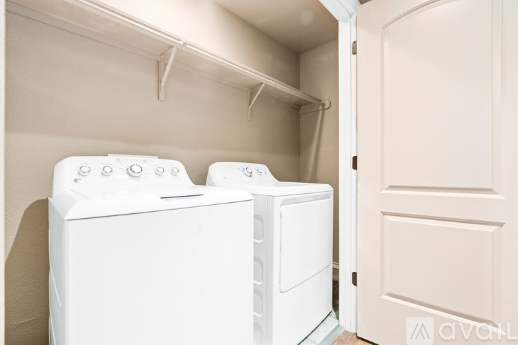 Two white front loading washing machines in a laundry room.
