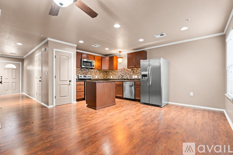 A kitchen with wooden floors and a refrigerator.