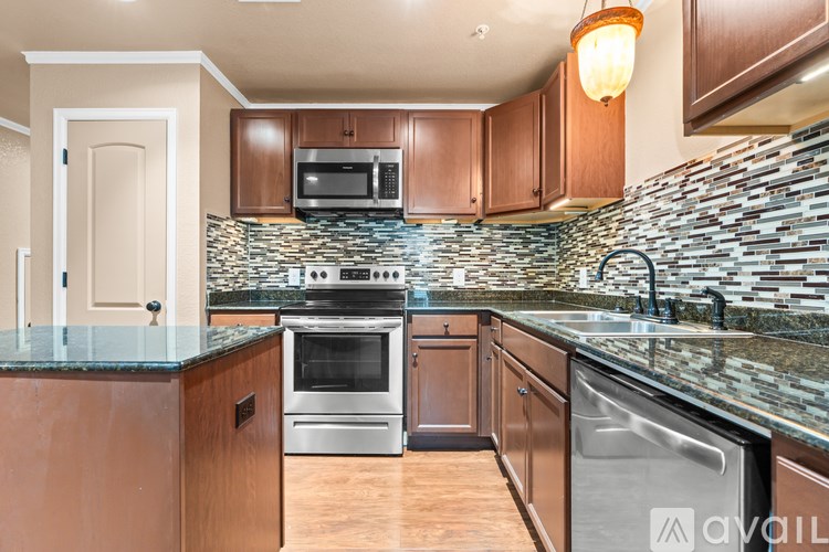 A kitchen with wooden cabinets and a stone backsplash.
