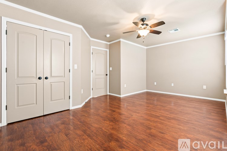A room with wood flooring and a ceiling fan.
